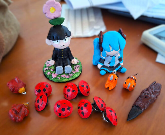 Air-dry clay figures, charms and pins painted with acrylics